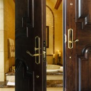 A view of two wooden doors with gold door, interior design, wood, black