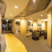 Entrance and foyer area of bank with armchair ceiling, floor, flooring, interior design, lobby, office, orange, brown