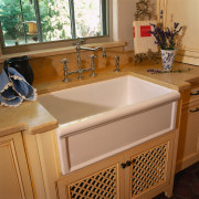 view of this bathroom area showing timber cabinetry, bathroom, bathroom accessory, bathroom cabinet, cabinetry, countertop, floor, flooring, furniture, kitchen, plumbing fixture, room, sink, brown, orange