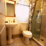 view of the bathroom featuring toilet, shower and bathroom, interior design, property, room, brown, orange