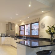 Kitchen with reflective black granite benchtops, light coloured ceiling, countertop, daylighting, interior design, kitchen, property, real estate, room, window, orange
