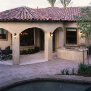 view of the clay tile roofing on this backyard, estate, facade, hacienda, home, house, outdoor structure, property, real estate, residential area, roof, window, black, white