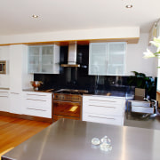 A view of a kitchen area, wooden flooring, cabinetry, countertop, cuisine classique, floor, flooring, hardwood, interior design, kitchen, living room, property, real estate, room, wood flooring, white