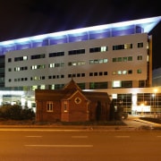 Exterior view of Christchurch Women's Hospital with raised architecture, building, city, corporate headquarters, facade, hotel, light, lighting, metropolitan area, mixed use, night, residential area, sky, structure, brown, black