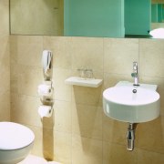 View of bathroom with white toilet, wall hung bathroom, bathroom accessory, bathroom sink, bidet, ceramic, floor, interior design, plumbing fixture, product design, property, public toilet, room, sink, tap, tile, toilet, toilet seat, wall, orange
