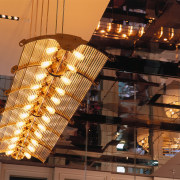 View of large suspended light fitting, and mirrored ceiling, light fixture, lighting, black, brown, orange