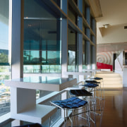 Bar stools and tables along window, with sun architecture, condominium, daylighting, glass, interior design, table, window, black