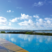 view of this  infinity edge pool that blue, calm, cloud, daytime, horizon, reflection, sea, sky, sunlight, swimming pool, water, water resources, waterway, blue, teal