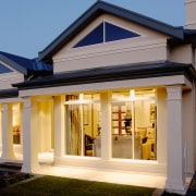 An exterior view of a plastered house, lawns building, estate, facade, home, house, lighting, property, real estate, residential area, roof, siding, window