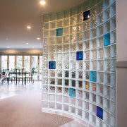 view of this glass block wall featuring solaris architecture, ceiling, daylighting, floor, flooring, glass, interior design, lobby, tile, wall, gray