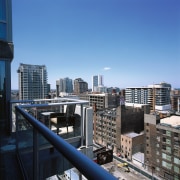 A view of the city from the glass apartment, architecture, building, city, cityscape, commercial building, condominium, corporate headquarters, daytime, downtown, metropolis, metropolitan area, mixed use, real estate, residential area, roof, sky, skyline, skyscraper, tower block, urban area, teal, black