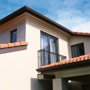 view of the house featuring wrought iron  architecture, balcony, building, daylighting, elevation, facade, home, house, property, real estate, residential area, roof, siding, sky, window, white