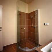 Frameless shower unit with brown wall and floor bathroom, door, floor, glass, plumbing fixture, room, shower, brown, orange