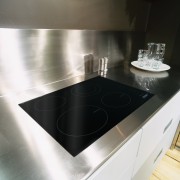 A view of a glass cooktop, stainless steel countertop, floor, kitchen, product design, sink, table, white, black