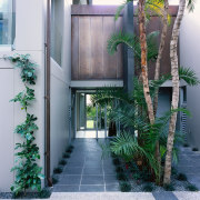 An exterior view of the entrance way to architecture, condominium, courtyard, facade, home, house, plant, property, real estate, gray