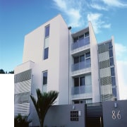 An exterior view of the apartments, plastered walls, apartment, architecture, building, commercial building, condominium, corporate headquarters, daytime, elevation, facade, home, house, mixed use, property, real estate, residential area, sky