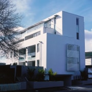 An exterior view of the apartments, plastered walls, apartment, architecture, building, commercial building, condominium, corporate headquarters, daytime, elevation, facade, headquarters, home, house, property, real estate, residential area, sky, blue