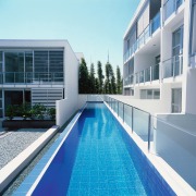 An exterior view of the swimming pool area. apartment, architecture, building, condominium, corporate headquarters, estate, facade, house, leisure, leisure centre, property, real estate, residential area, swimming pool, water, white, teal