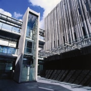 A view of the elevators within the complex. architecture, building, commercial building, condominium, corporate headquarters, daytime, facade, headquarters, metropolis, metropolitan area, mixed use, skyscraper, structure, black, gray