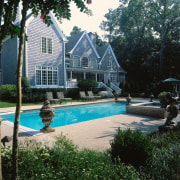 An exterior view of the entire pool and backyard, cottage, estate, home, house, landscape, landscaping, leisure, outdoor structure, plant, property, real estate, reflection, residential area, swimming pool, tree, water, yard, black