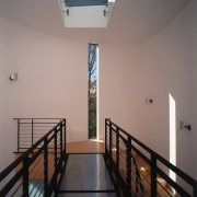 A view of a hallway, wooden flooring, white apartment, architecture, ceiling, daylighting, estate, floor, handrail, home, house, interior design, property, real estate, stairs, window, wood, gray