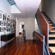 Interior view of the homes hallway and stairwell. architecture, ceiling, daylighting, floor, flooring, handrail, hardwood, house, interior design, laminate flooring, loft, real estate, stairs, wood, wood flooring, red, gray