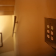 A view of the keypad used to control home, house, light, light fixture, lighting, room, tourist attraction, wood, brown