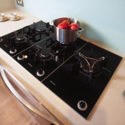 A view of a kitchen, wooden cabinetry and countertop, black