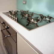 A view of a kitchen, wooden cabinetry, white countertop, glass, product design, table, gray