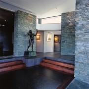 view of the entrance to the house featuring architecture, ceiling, floor, flooring, interior design, lobby, wall, black, gray