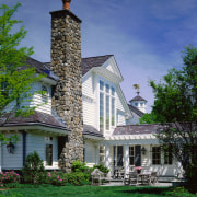 Exterior view of home with white cladding, grey architecture, building, cottage, estate, facade, farmhouse, grass, historic house, home, house, lawn, mansion, outdoor structure, property, real estate, residential area, roof, sky, tree, blue