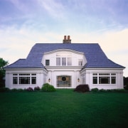 Exterior view of large home with white cladding, cottage, elevation, estate, facade, farmhouse, home, house, mansion, property, real estate, residential area, roof, shed, siding, sky, window, teal