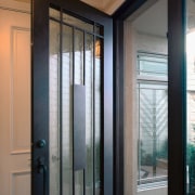 Closeup of wrought iron and glass entry door. door, glass, home, interior design, window, gray, black