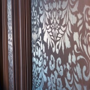 Closeup of stencilling on wall panel. - Closeup curtain, design, interior design, pattern, textile, wall, wallpaper, wood, gray, black