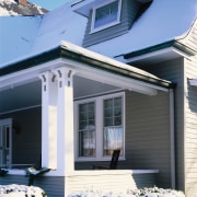 the witches hat dormar window  features a building, cottage, elevation, facade, home, house, porch, property, real estate, residential area, roof, siding, snow, window, winter, teal, black