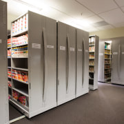 A view of some shelving storage systems. - floor, flooring, institution, shelf, shelving, gray