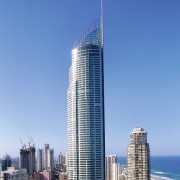 Exterior view of tall Q1 Tower apartment building. architecture, building, city, cityscape, condominium, corporate headquarters, daytime, downtown, landmark, metropolis, metropolitan area, mixed use, sky, skyline, skyscraper, tower, tower block, urban area, blue