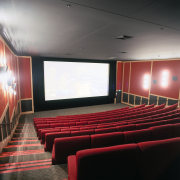 Movie theatre with red seating, red and black auditorium, ceiling, conference hall, interior design, movie theater, performing arts center, theatre, black