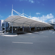 View of large sail-like canopy providing shelter outside airport, airport terminal, architecture, building, corporate headquarters, daylighting, infrastructure, sky, structure, gray, blue