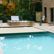 A view of a swimming pool. - A backyard, home, house, leisure, outdoor furniture, outdoor structure, real estate, reflection, residential area, swimming pool, water, water feature, wood, yard, teal, white