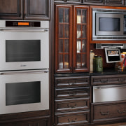 View of traditional style kitchen with dark wood cabinetry, countertop, furniture, home appliance, kitchen, kitchen appliance, kitchen stove, major appliance, microwave oven, oven, refrigerator, black, gray