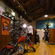 Interior view of retail clothing shop with timber car, land vehicle, motor vehicle, motorcycle, tourist attraction, vehicle, brown, black