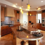 view of this kitchen featuring walnut coliseum Stone, cabinetry, ceiling, countertop, cuisine classique, floor, flooring, hardwood, interior design, kitchen, lighting, room, under cabinet lighting, wood flooring, brown