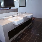 view of the bathroom featuring tiled flooring, glased bathroom, bathroom sink, countertop, floor, flooring, interior design, plumbing fixture, product design, sink, tap, tile, gray, black