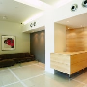view of this apartment that has a sleek ceiling, floor, flooring, interior design, living room, lobby, wall, white, orange