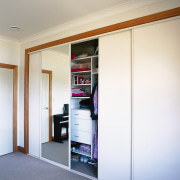 View of wardrobe storage system with sliding doors. door, furniture, interior design, room, sliding door, wardrobe, wood, white