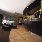 Hotel bar with curved counter and square stools ceiling, floor, flooring, interior design, lobby, black