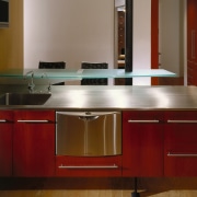 Kitchen with red cabinetry, stainless steel dishwasher drawer, cabinetry, countertop, floor, flooring, furniture, glass, hardwood, interior design, kitchen, product design, room, sink, table, red, brown