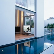 Lap pool next to house, with view of architecture, condominium, daylighting, glass, house, interior design, property, real estate, swimming pool, window, white, teal