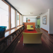 view of this hallway featuring timber bookcase, red architecture, ceiling, floor, flooring, house, interior design, living room, property, real estate, room, table, black, white